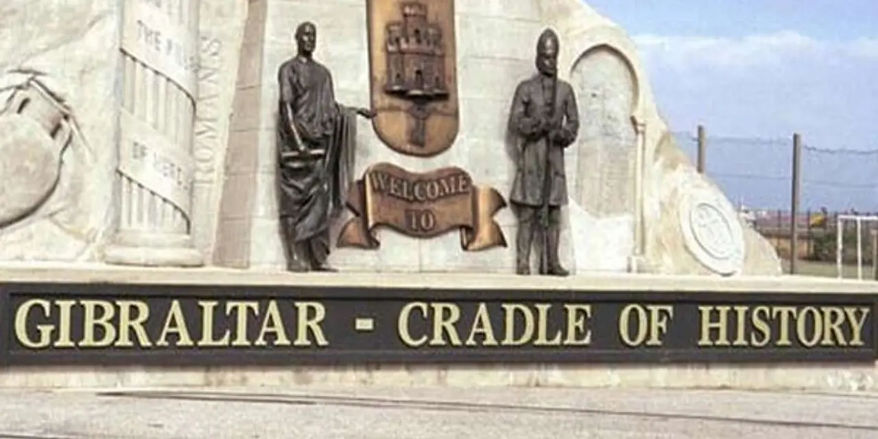 A stone monument reading 'Gibraltar – Cradle of History' with two bronze figures either side of the Gibraltar crest