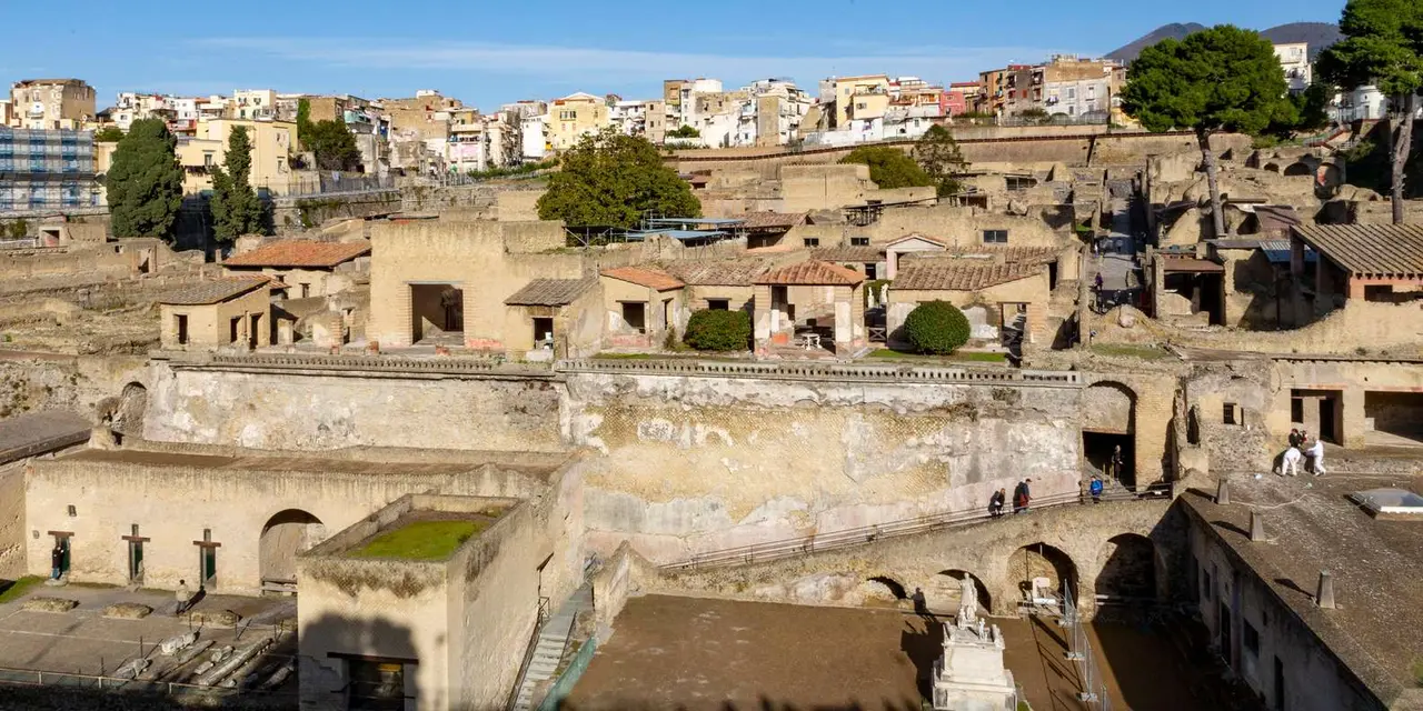 The excavated streets and roofless houses of Herculaneum below the modern town