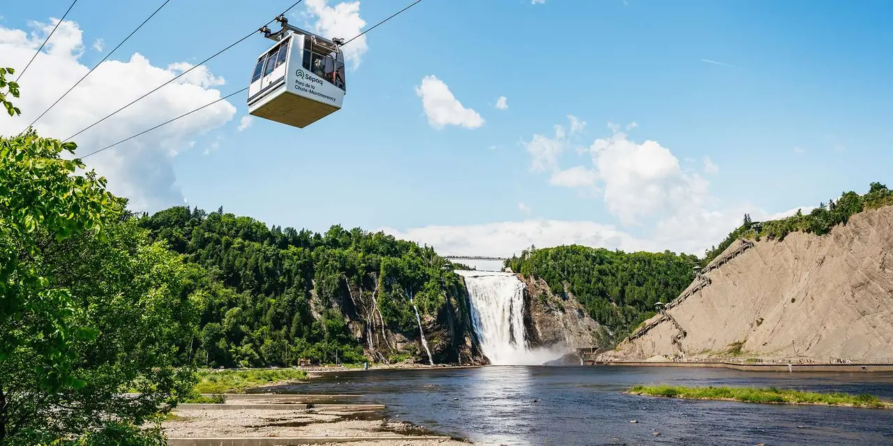 A cable car gondola gliding over the trees beside Montmorency Falls