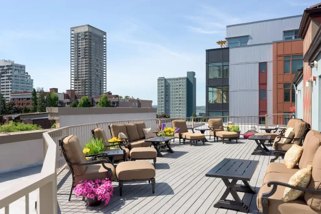 The Belltown Inn's furnished rooftop deck with flower planters and Belltown towers behind