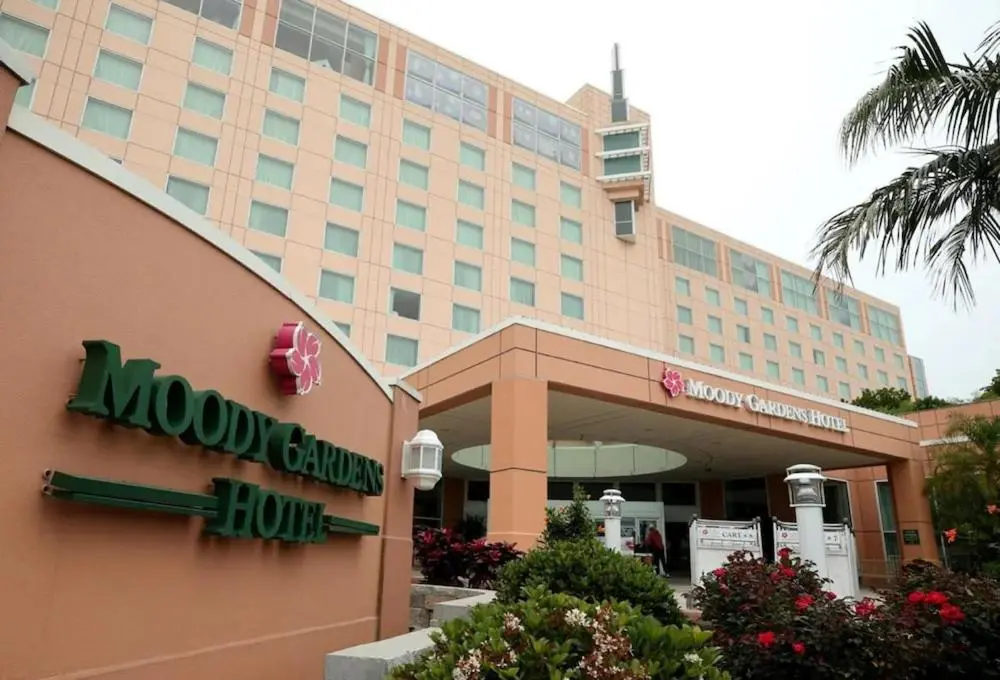 Moody Gardens Hotel's peach-coloured tower and entrance canopy, with the hotel sign in the foreground