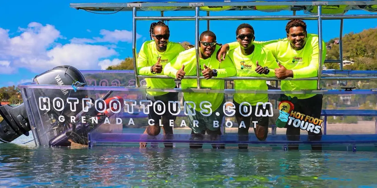 A crew in matching yellow shirts sitting in a transparent boat