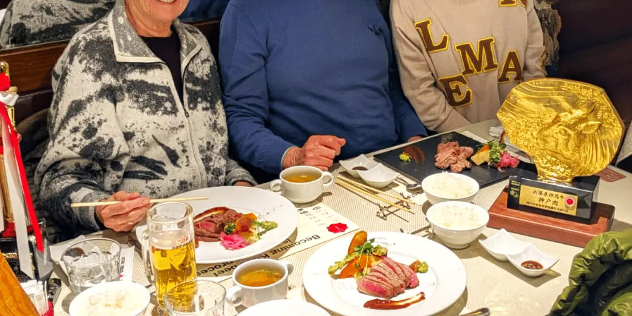 Tour guests at a restaurant table with plates of food and glasses of beer