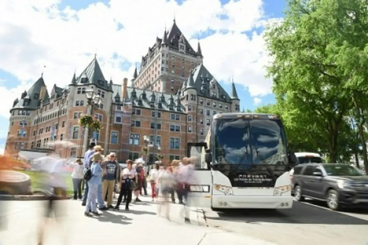 Québec's Parliament Building with statues and lawns under a blue sky