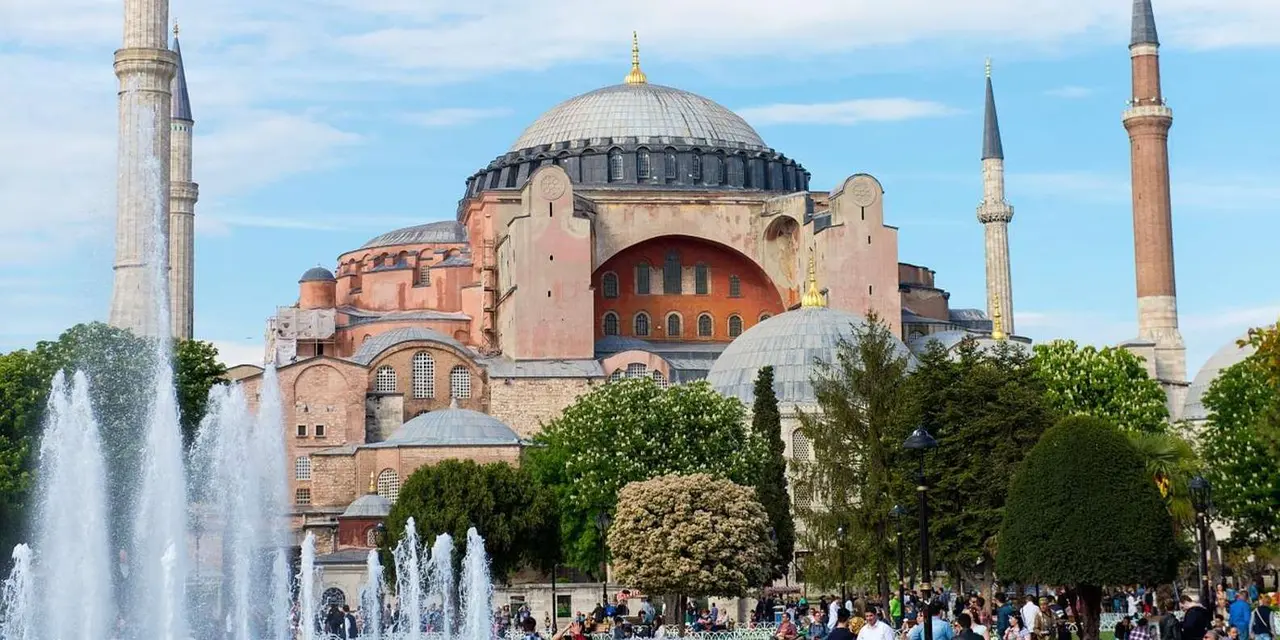Hagia Sophia's domes and a minaret against a clear blue sky