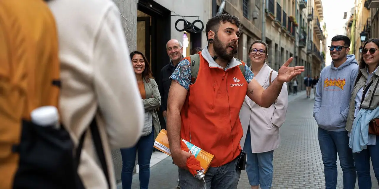 A guide in an orange vest speaking to a smiling group on a cobbled street