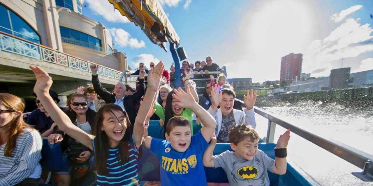 Children cheering aboard the Harbour Hopper with the Halifax skyline behind them