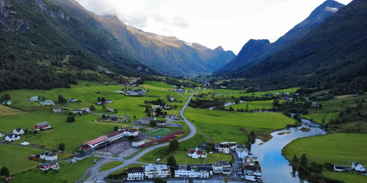 An aerial view of Olden village in its green valley with the river and mountains
