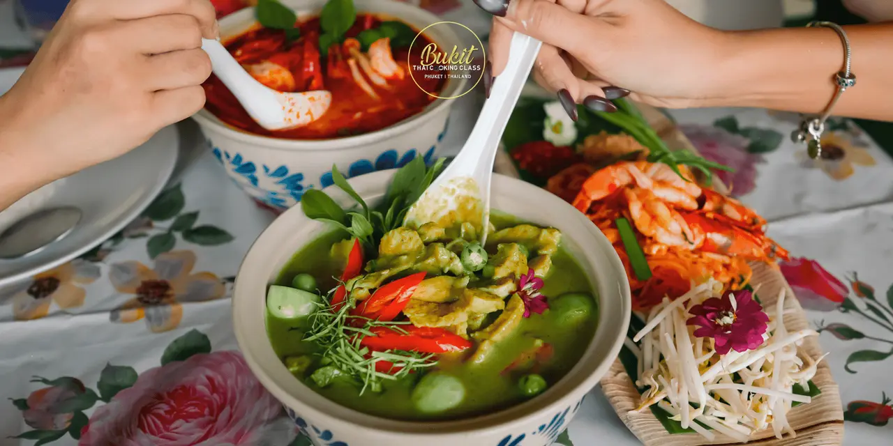 Bowls of green curry and tom yum soup on a table