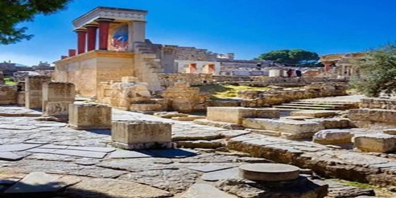 The reconstructed north entrance of Knossos, with red columns and a bull fresco above stone ruins