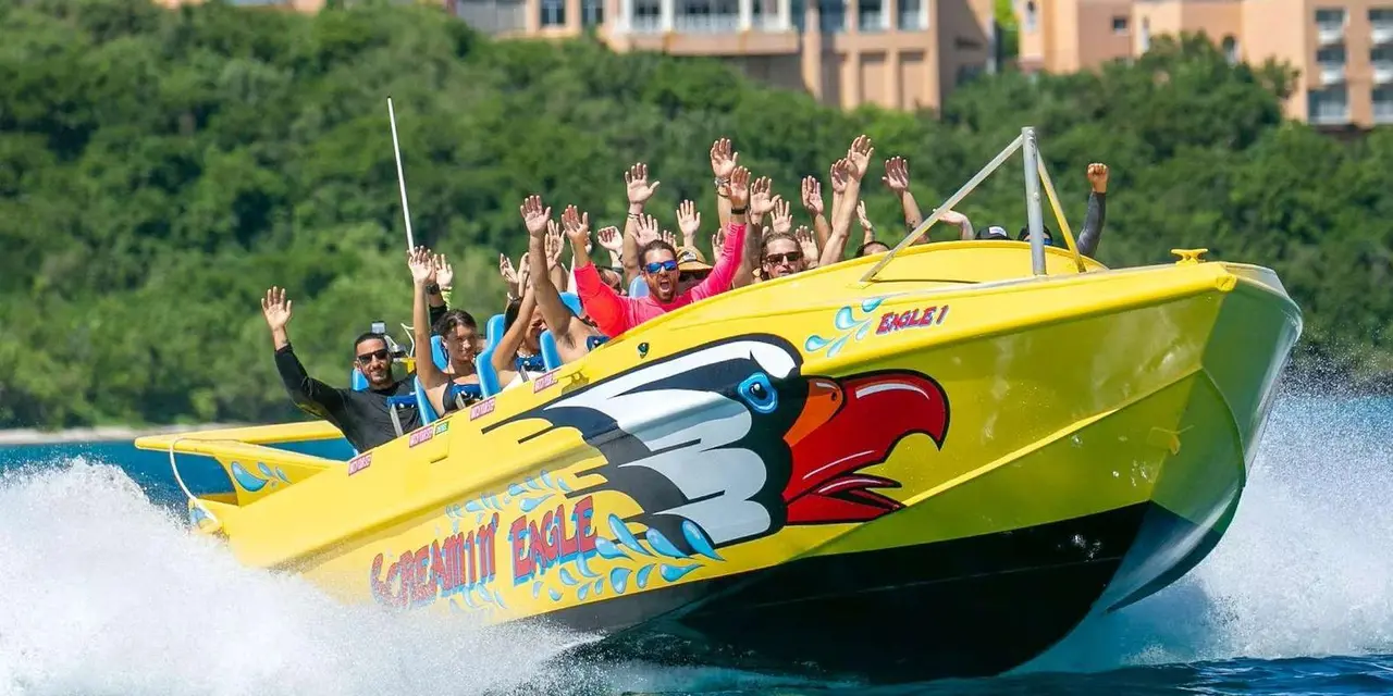 A yellow jet boat with an eagle painted on its bow banking hard through spray, its passengers raising their arms