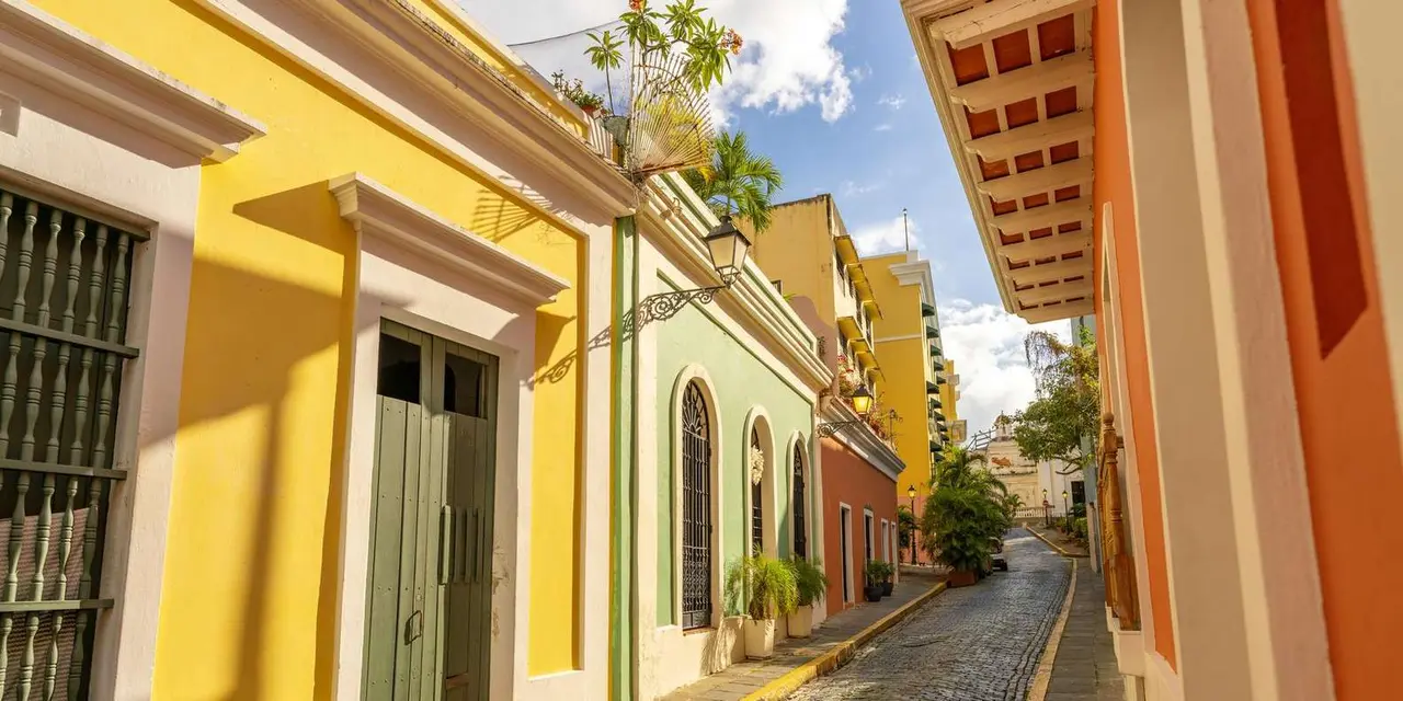 A cobblestone Old San Juan street lined with yellow colonial buildings