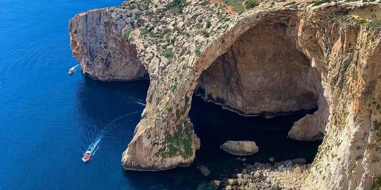 The Blue Grotto's limestone sea arch above deep blue water