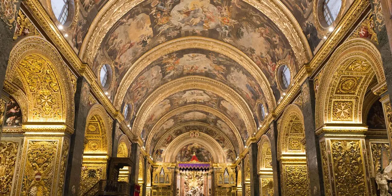 The gilded, painted nave of St John's Co-Cathedral, lined with carved arches