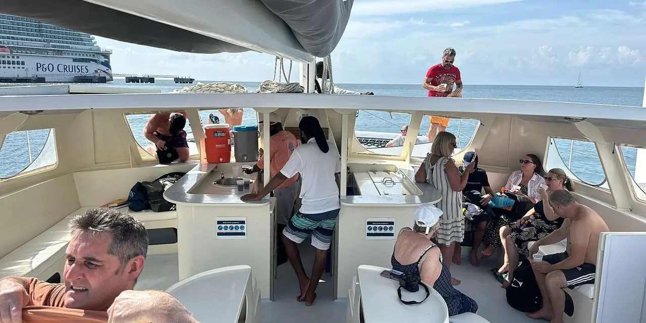 Passengers relaxing in the shaded cockpit of a catamaran at sea