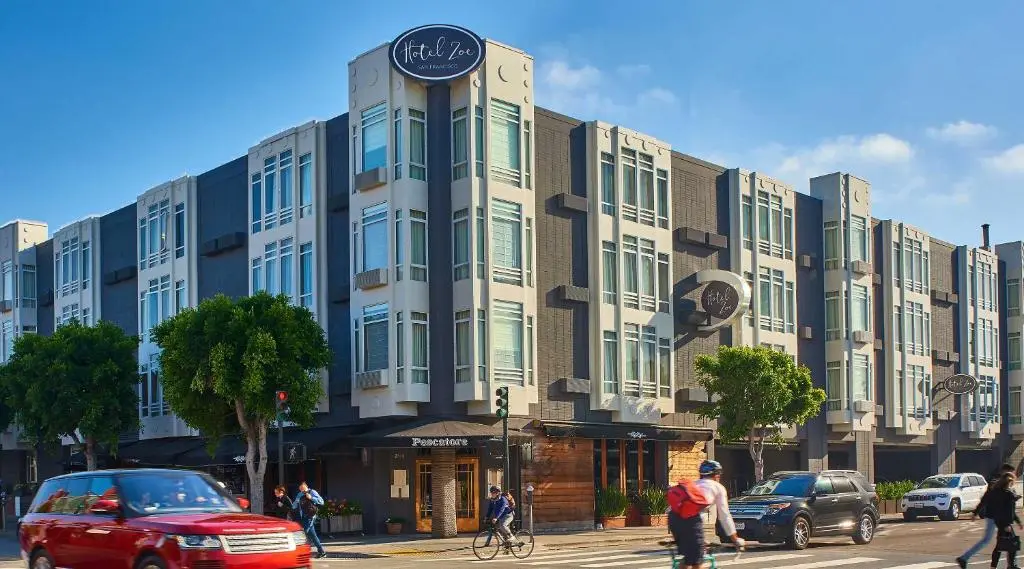 Hotel Zoe's grey bay-windowed facade on the corner of North Point Street under a blue sky