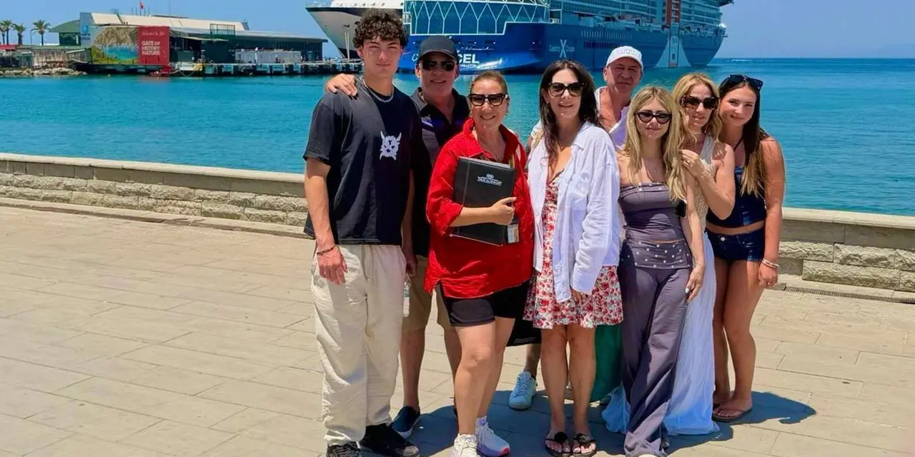 A tour group posing on the Kuşadası waterfront promenade with a large cruise ship docked behind