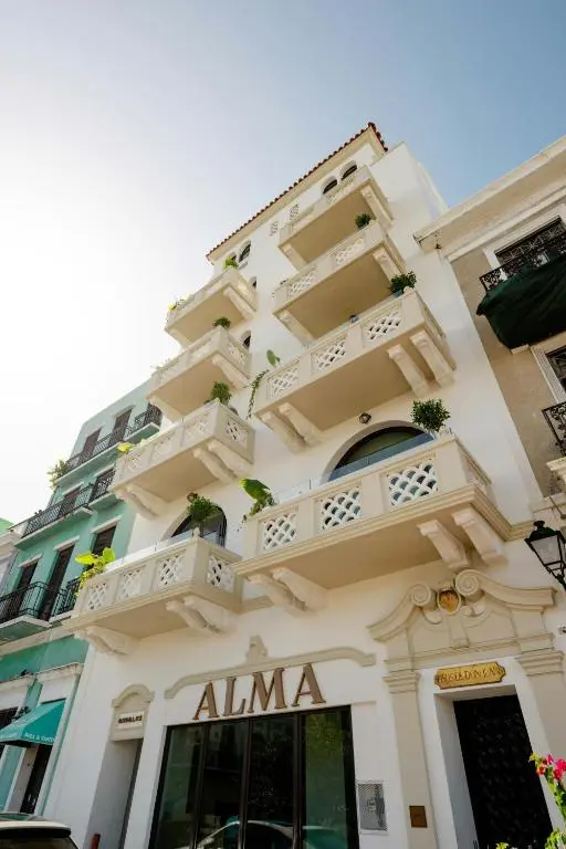 Alma's cream-coloured historic building in Old San Juan, with stacked balconies, potted plants and the hotel's name over the entrance
