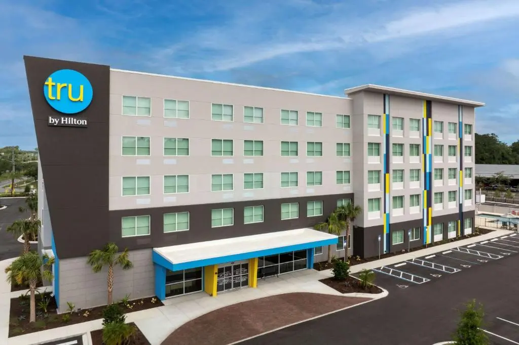 Tru by Hilton Jacksonville Airport, a five-storey building with a blue and yellow entrance canopy and the round tru sign
