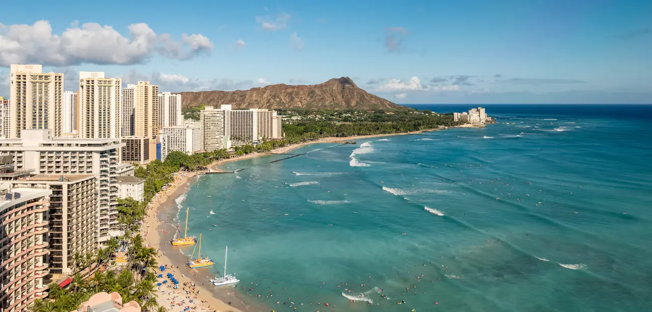 Waikīkī's hotel towers and beach curving toward Diamond Head along turquoise water