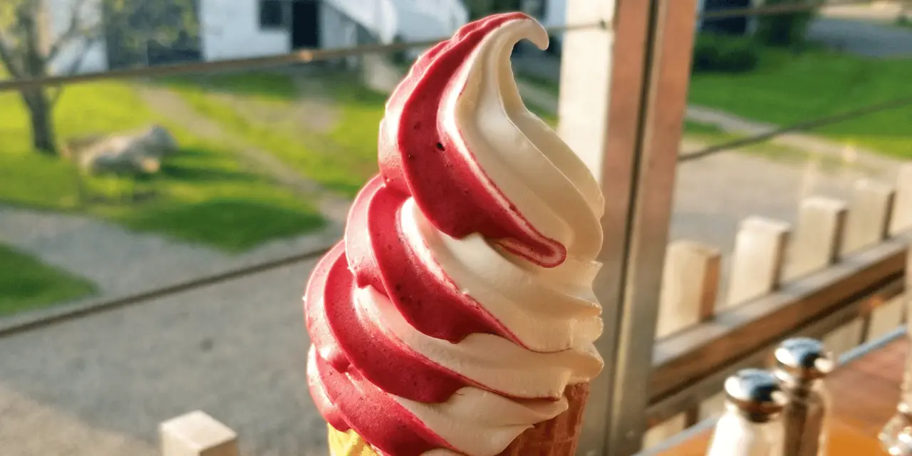A swirled strawberry-and-vanilla soft-serve cone