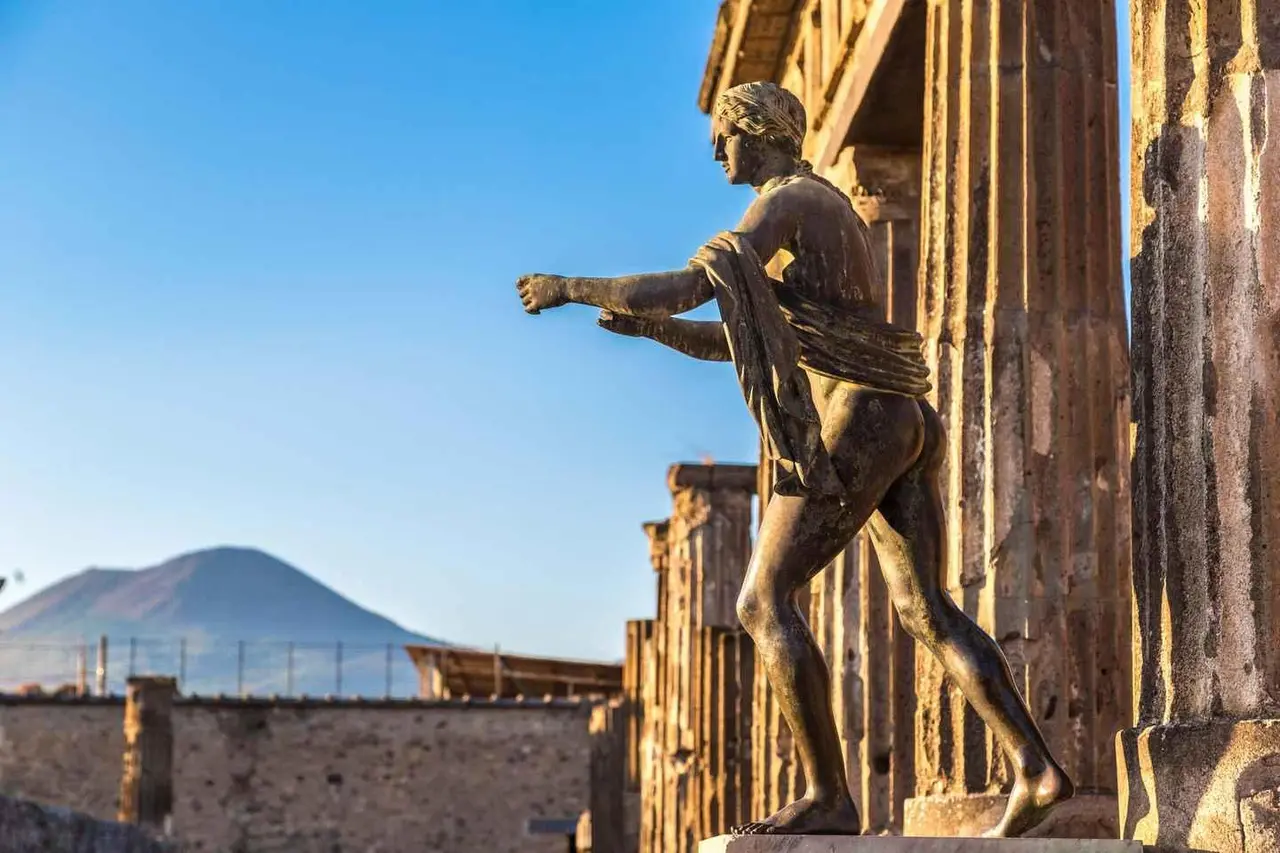 The bronze Apollo statue at the Temple of Apollo in Pompeii, with Vesuvius behind under a blue sky
