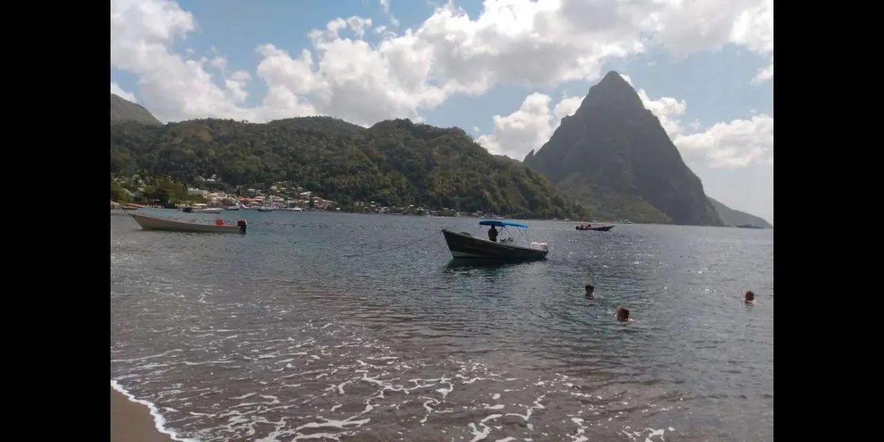 A pointed Piton rising behind a bay with moored boats