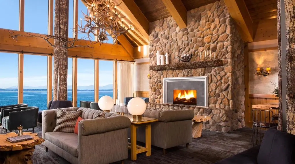 The Edgewater's lounge with a stone fireplace and floor-to-ceiling windows looking over Elliott Bay