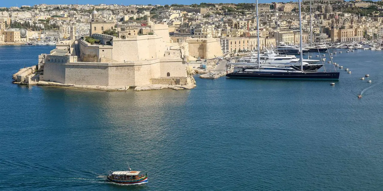 Fort St Angelo on its point across the blue Grand Harbour, with the stone houses of the Three Cities behind