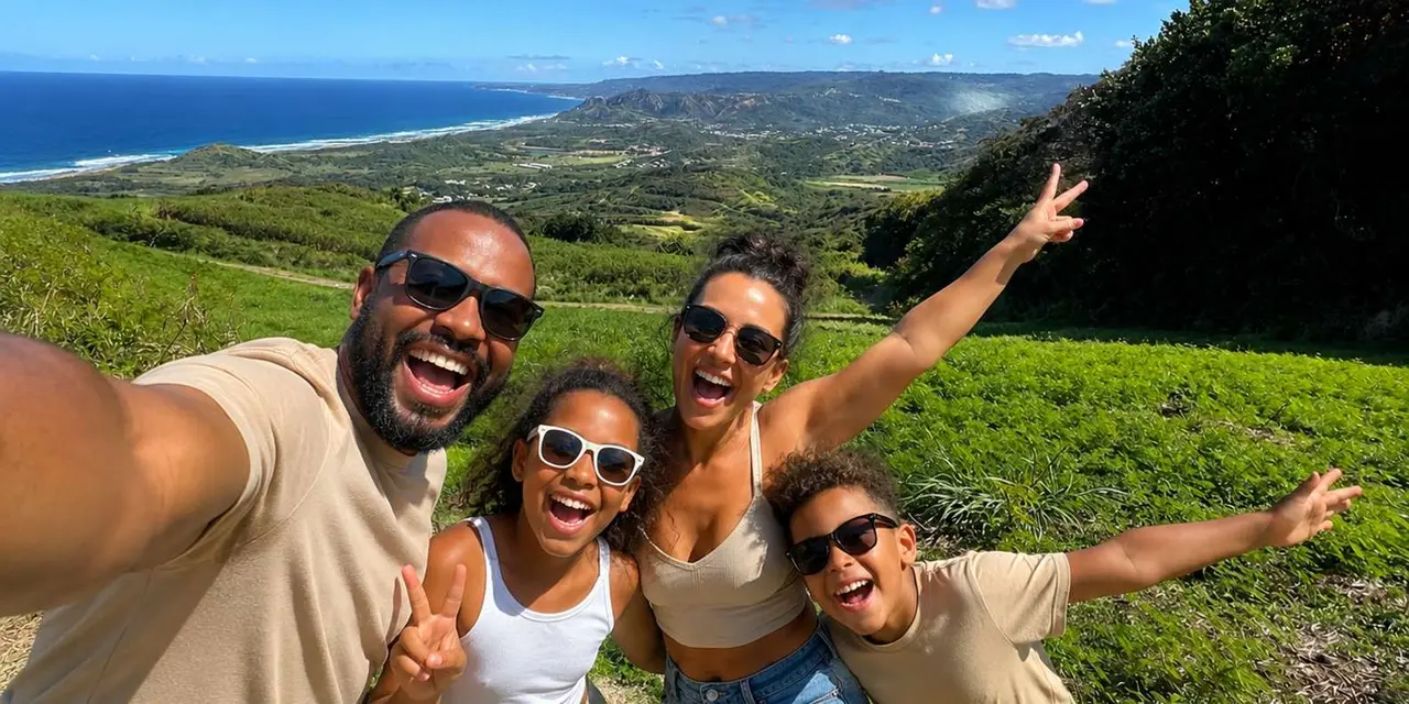 A smiling family taking a selfie on a green hillside above the east coast
