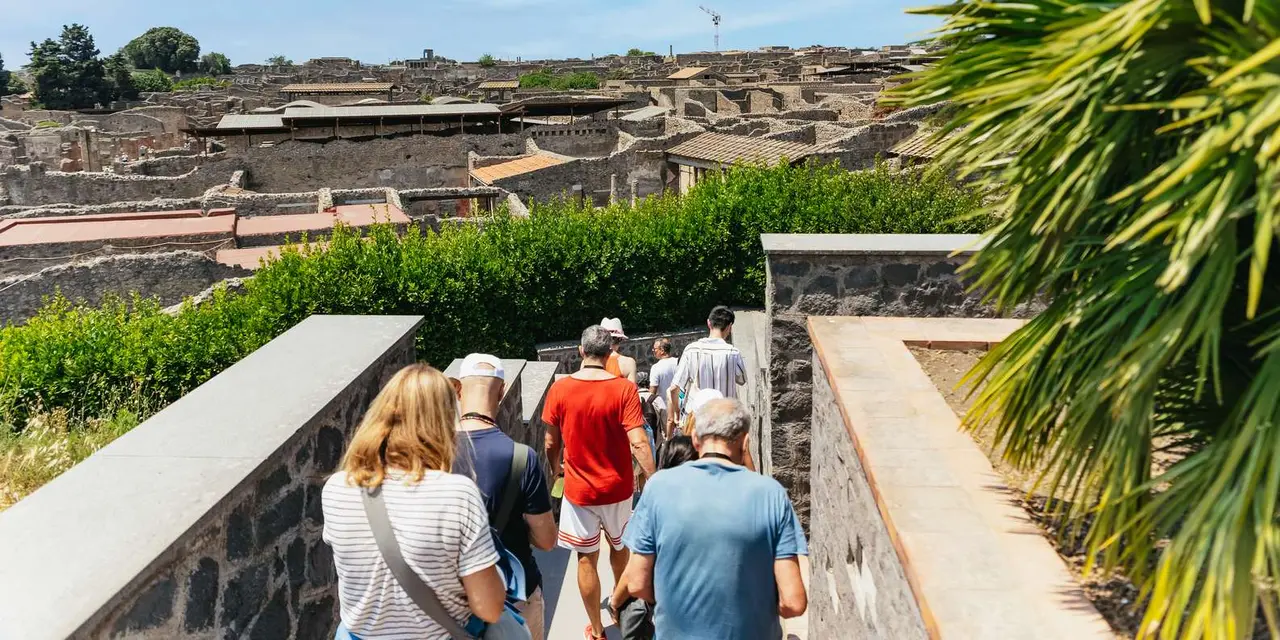 A tour group on a terrace looking out over the ruins of Pompeii