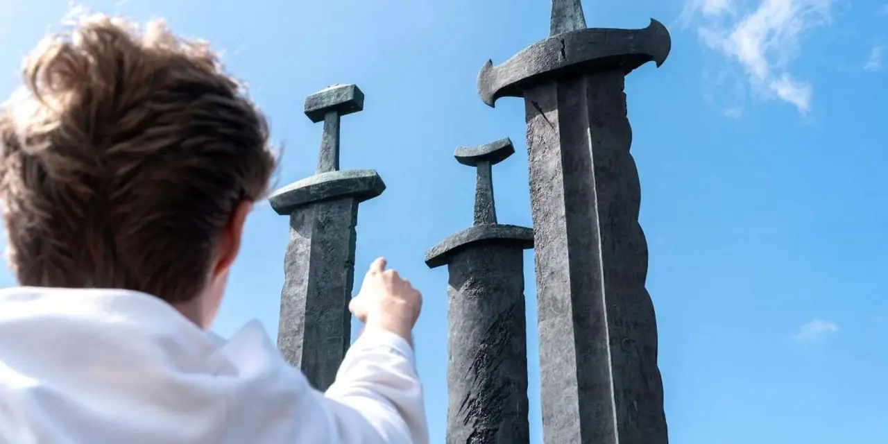 Three giant bronze swords of the Swords in Rock monument against a blue sky