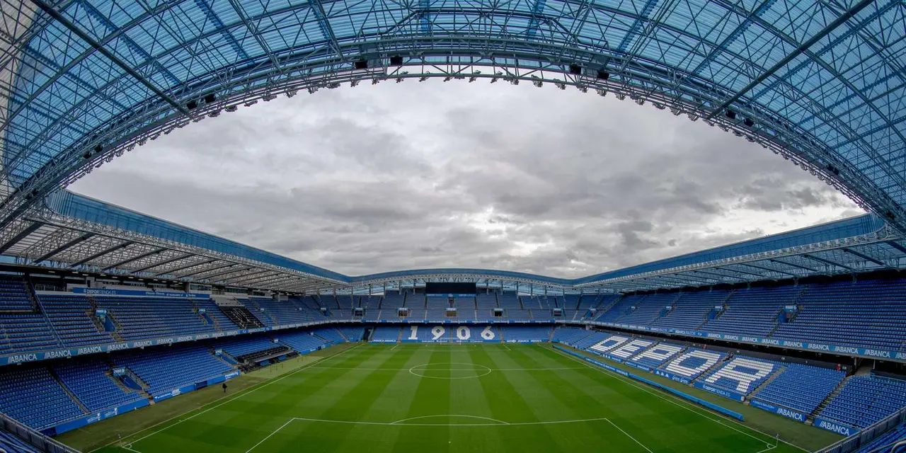 The empty Riazor football stadium seen from the stands, with DEPOR spelled out in the seats