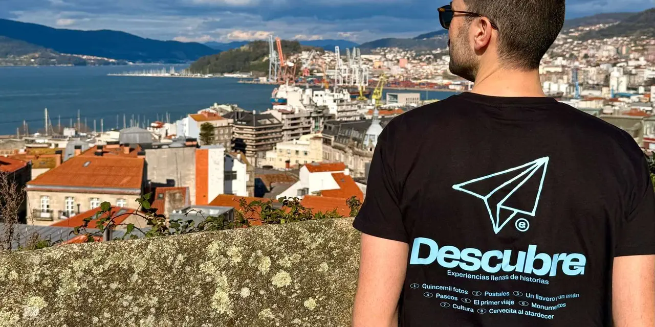 A guide in a black T-shirt looking out over Vigo's rooftops, its port and the ría from a hillside viewpoint