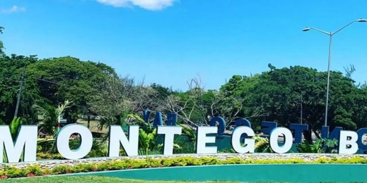 The large 'MONTEGO' letters sign on a lawn under a blue sky