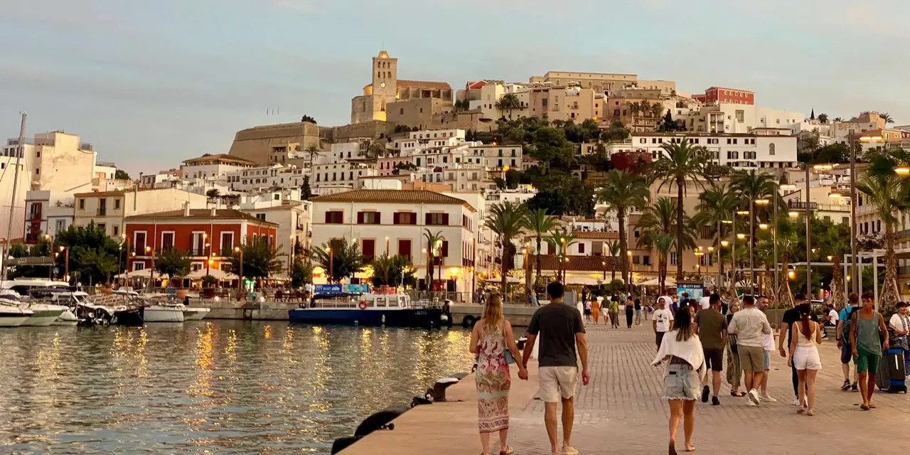 The Dalt Vila skyline with the cathedral tower above the harbour front and the City Boat moored, at dusk