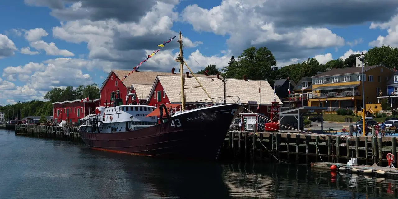 Lunenburg's waterfront with red buildings and a moored tall ship