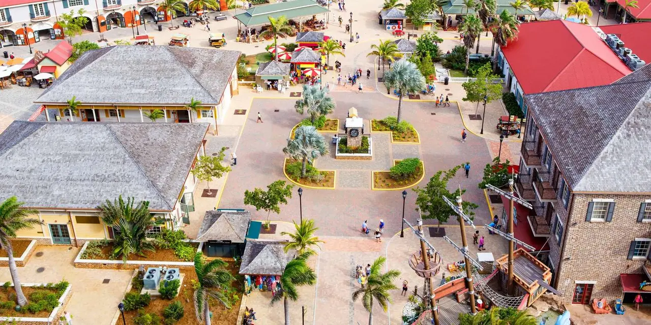 Aerial view of the Falmouth cruise port plaza with red-roofed shops and palm trees