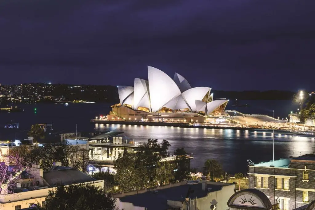 Night view over The Rocks' rooftops to the lit-up Sydney Opera House across Circular Quay, seen from Rendezvous Hotel Sydney The Rocks