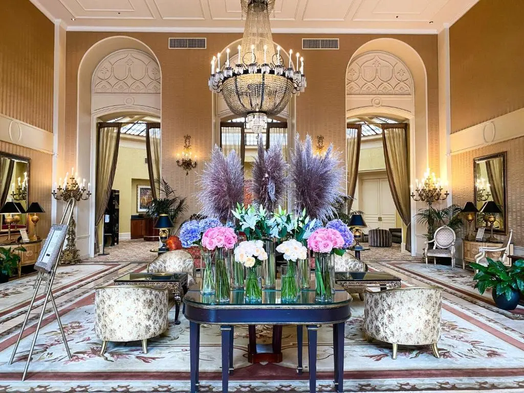 The Mark Hopkins lobby, with a crystal chandelier over a table of fresh flowers between arched windows