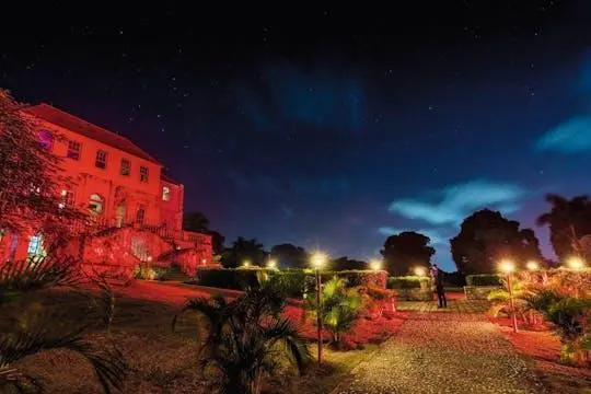 Rose Hall Great House lit up at night under a starry sky
