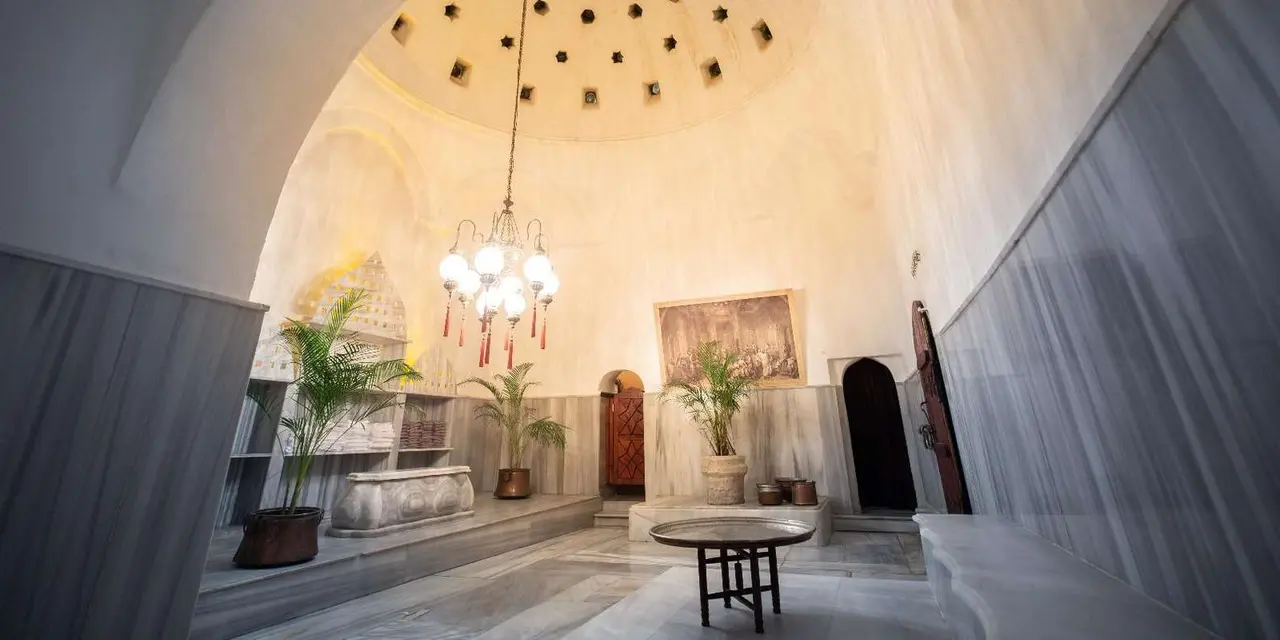 The domed marble hall of the Cağaloğlu Hamam with a chandelier and star-shaped skylights