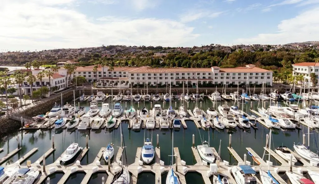 The DoubleTree San Pedro's low red-roofed buildings behind the yachts of Cabrillo Marina under a clear sky