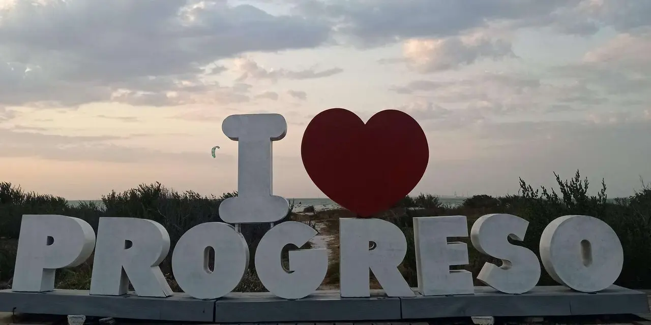 Large white 'I love Progreso' letters with a red heart against a pale evening sky
