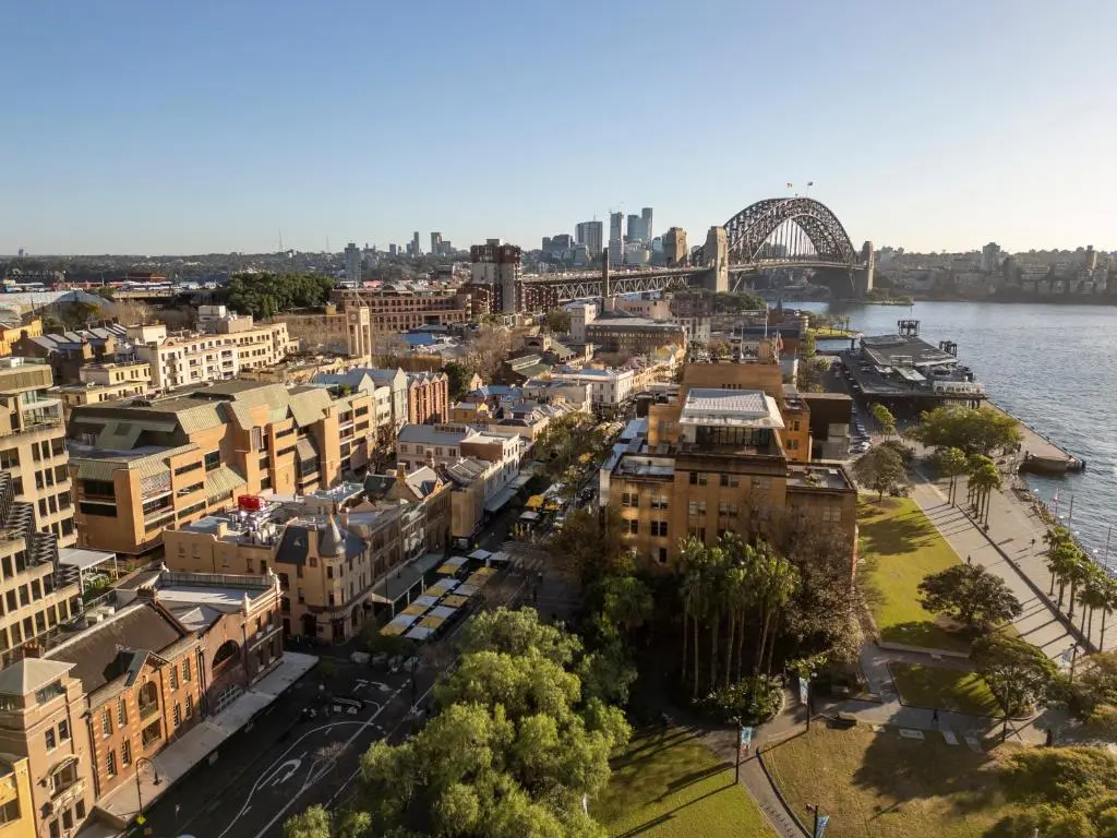 Aerial view over The Rocks in Sydney with The Russell's sandstone building among the old streets, Circular Quay's waterfront and the Harbour Bridge behind