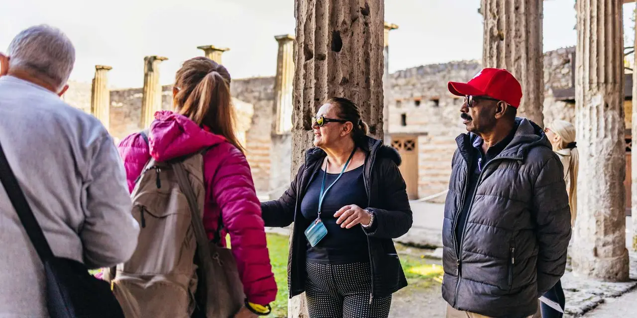 A guide talking to a small group among the ruined columns of Pompeii