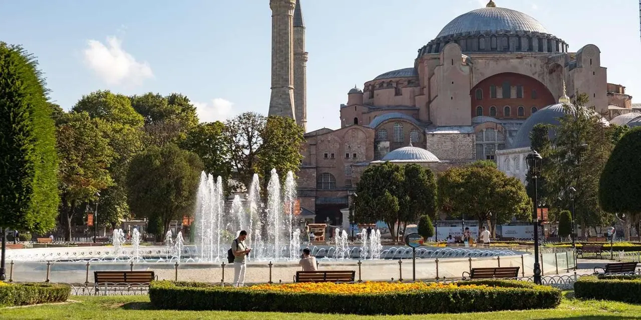 Hagia Sophia seen across the fountain and trees of Sultanahmet Park