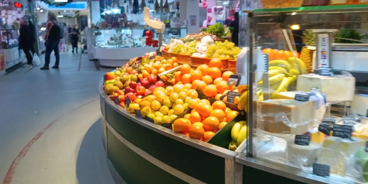 A market stall piled high with oranges, lemons and other fresh fruit
